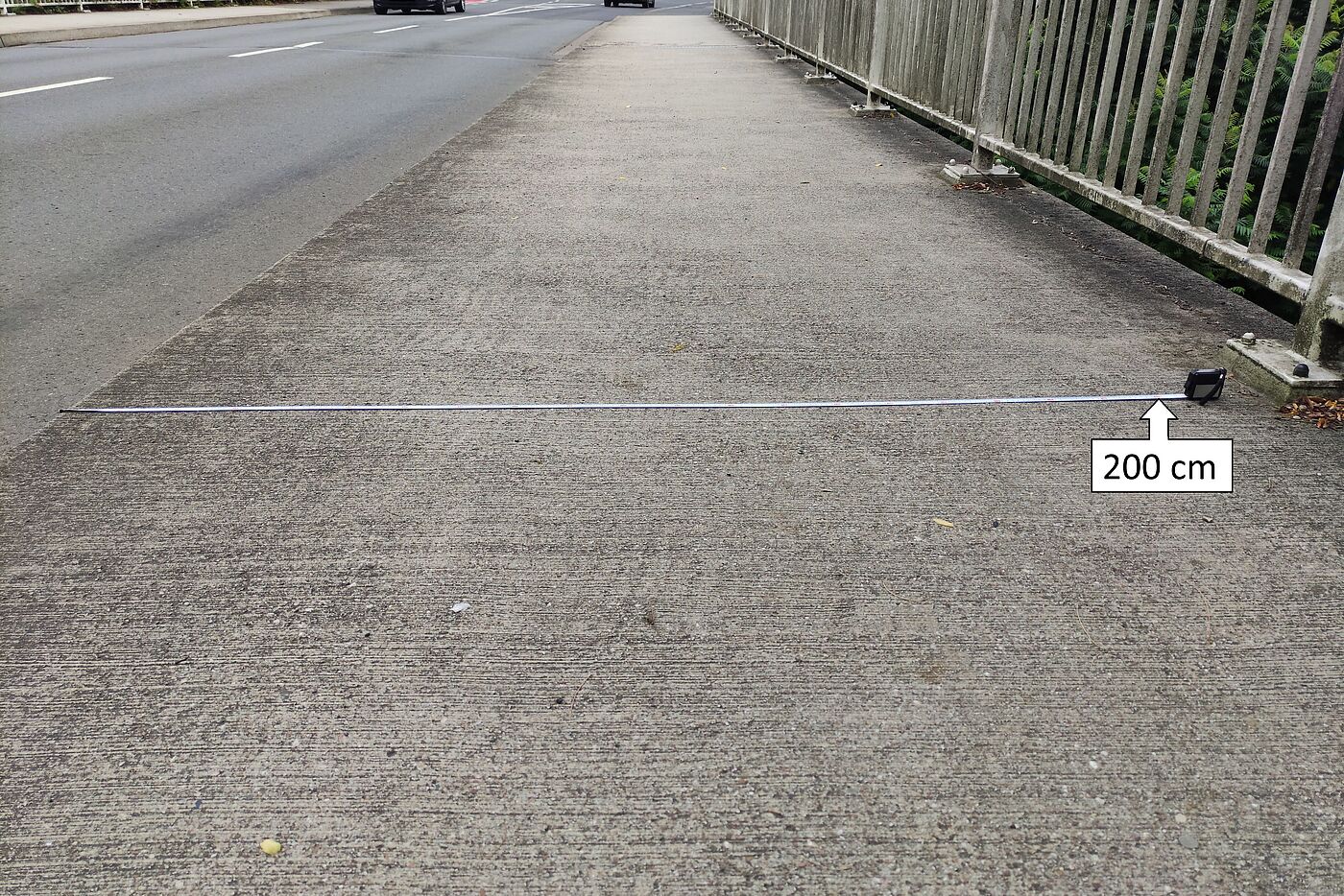 2 Meter langes Maßband liegt auf dem Gehweg