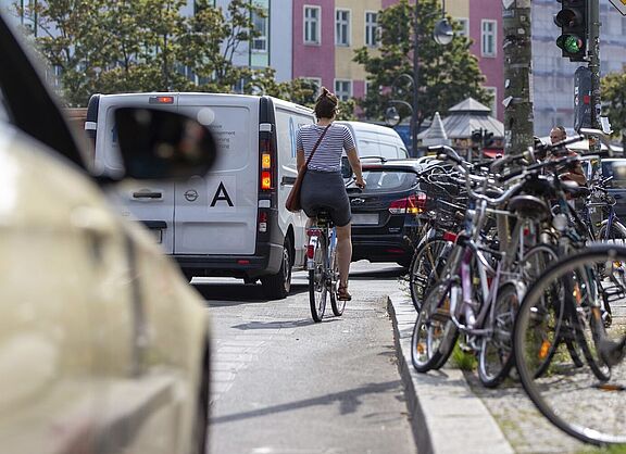 Aufmacher StVG-Buendnis Radfahrerin auf Fahrbahn, bedrängt von Kfz.